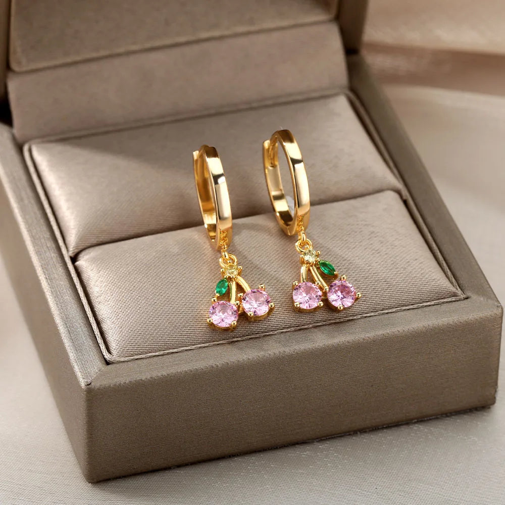 Gold hoop earrings with pink gemstones in a jewelry box
