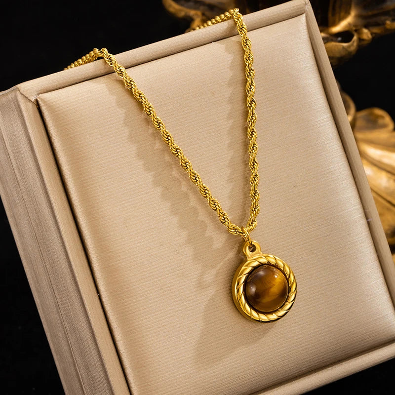 Gold necklace with a pendant on a beige jewelry box