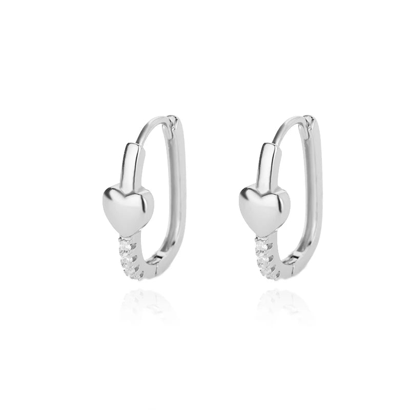 Silver hoop earrings with heart-shaped ends on a white background