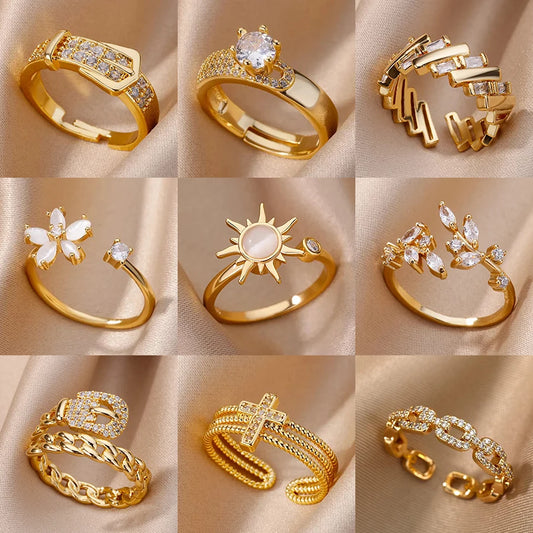 Collection of gold rings with various designs on a beige fabric background