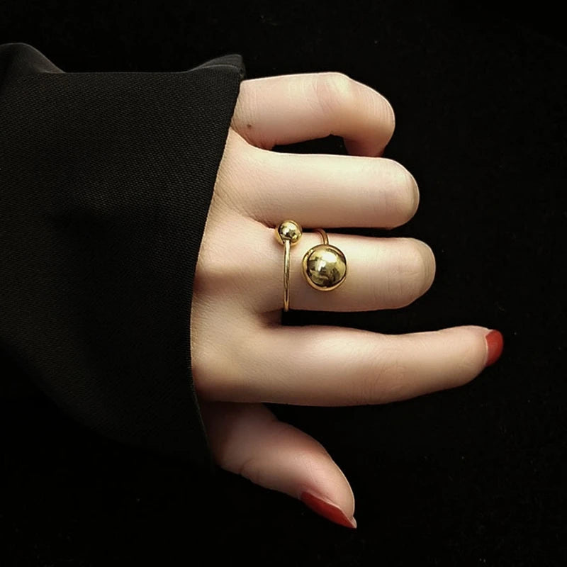 Gold ring on a hand with a black background