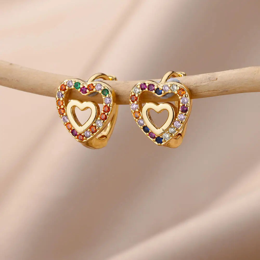 Heart-shaped earrings with colorful gemstones on a beige background