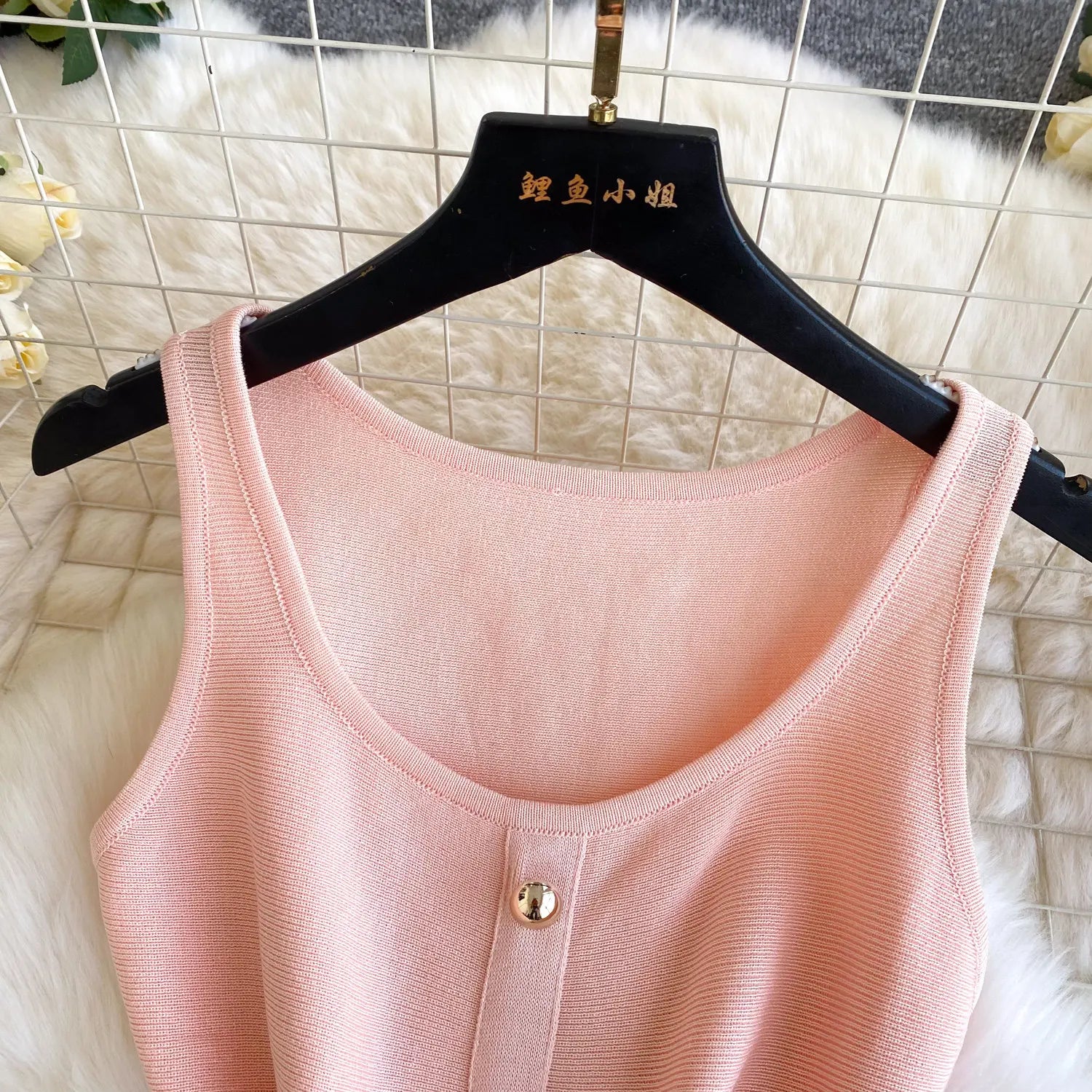Pink tank top on a hanger with a textured background