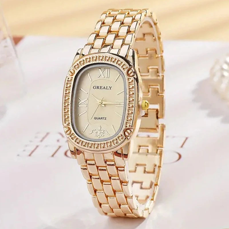 Gold wristwatch with a detailed face on a light background
