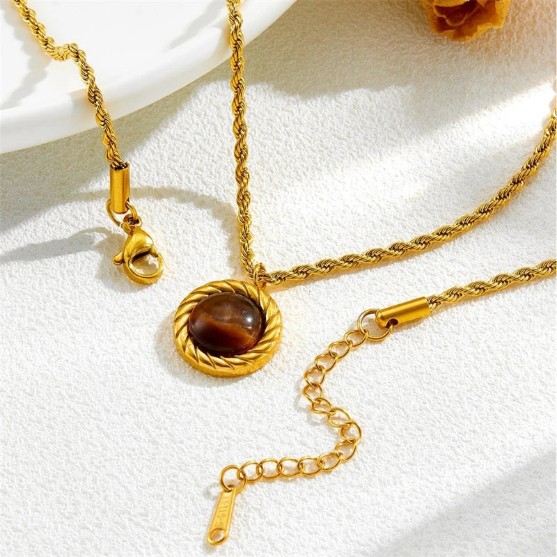 Gold necklace with a circular pendant on a white background