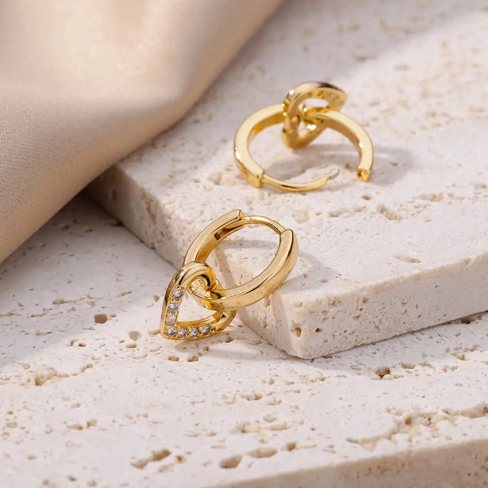 Gold hoop earrings on a textured beige surface