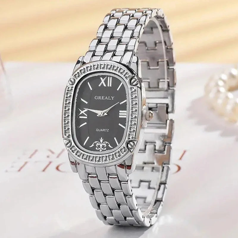 Silver watch with black dial on a light background