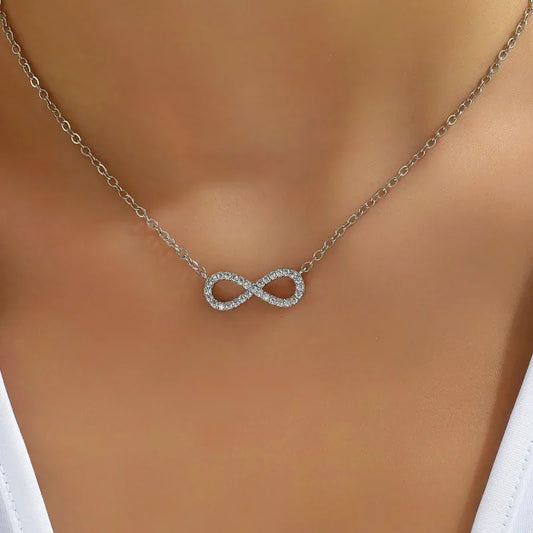 Silver infinity necklace on a mannequin with a white top