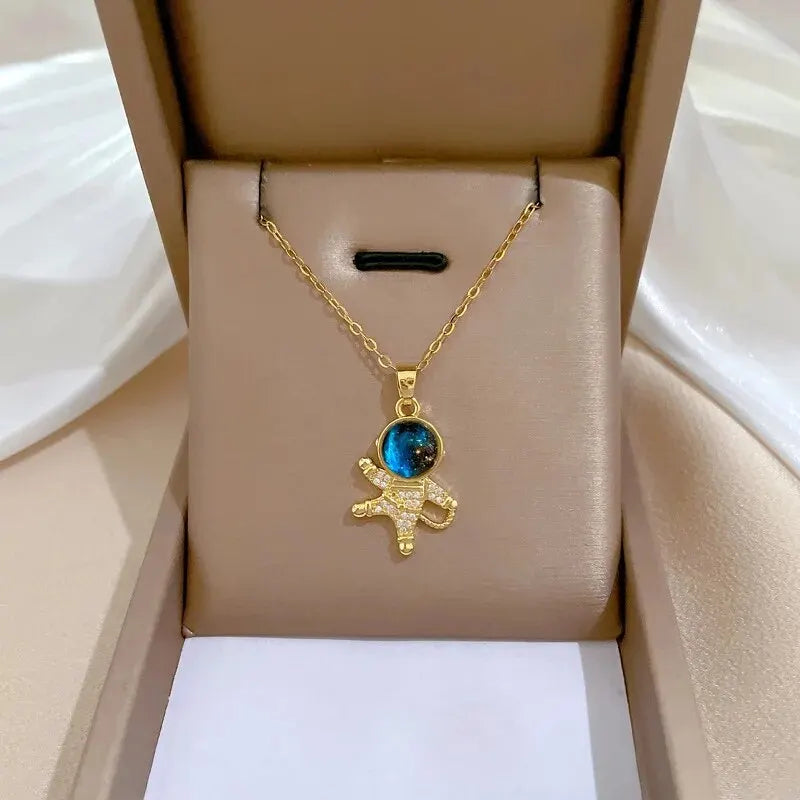 Gold astronaut pendant necklace with blue and black enamel details on a delicate chain Unknown Product