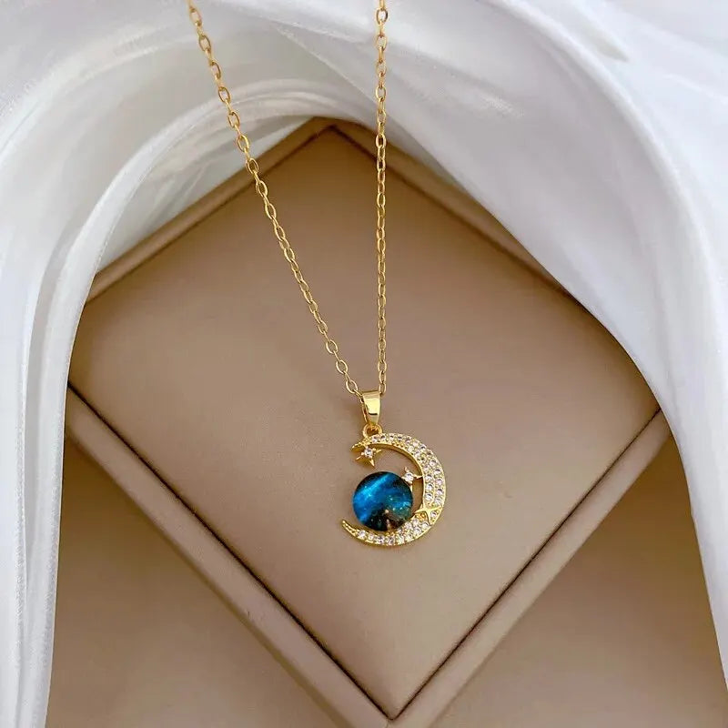 Unknown Product gold necklace with crescent moon pendant and blue spherical stone on beige background